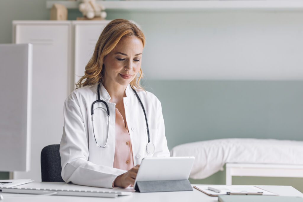 Blonde Medical Doctor Using a Digital Tablet at the Office